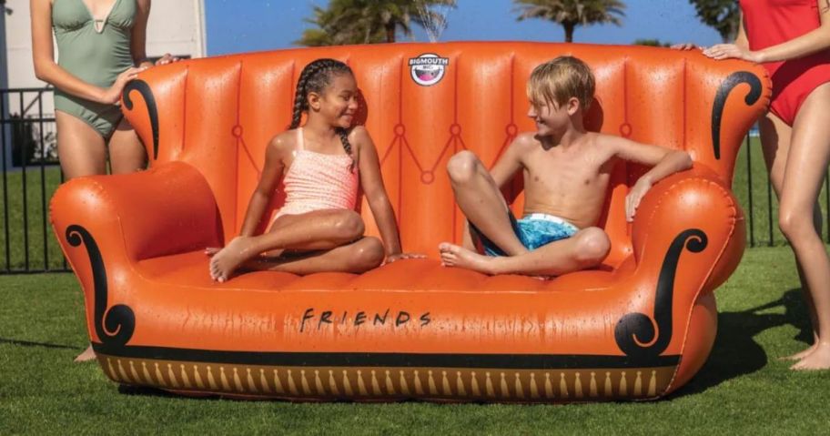 Kids sitting on an inflatable Friends couch