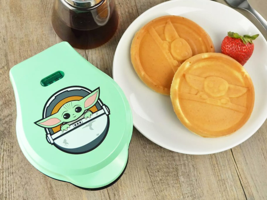 green waffle maker next to "the child" mini waffles on plate