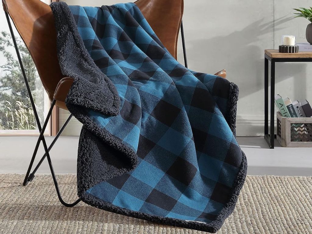 A blue and black plaid Eddie Bauer throw blanket on a chair