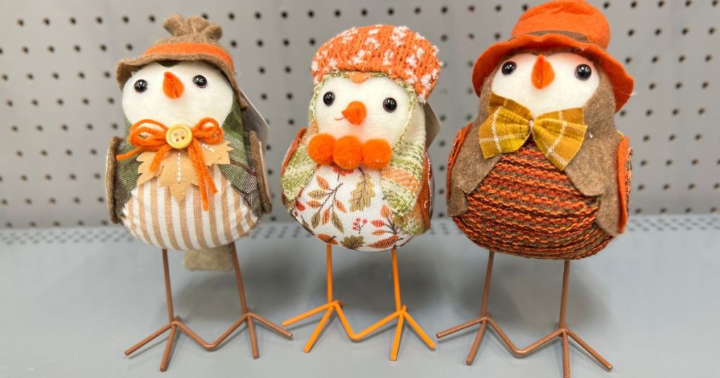 3 small fabric birds dressed in fall outfits on a shelf 