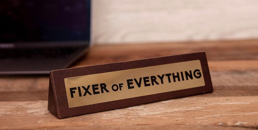 fixer of everything wooden desk sign with gold plaque on desk
