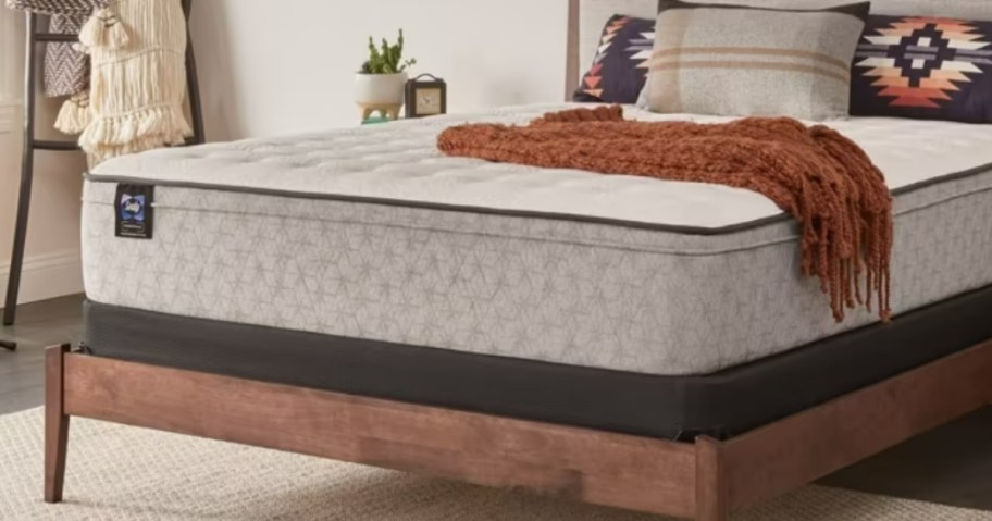 a mattress in a bedroom with pillows and a blanket on it