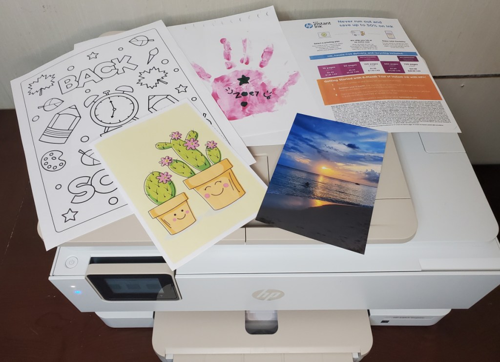 An hp envy inspire 7955e with examples of printed sheets on top of it