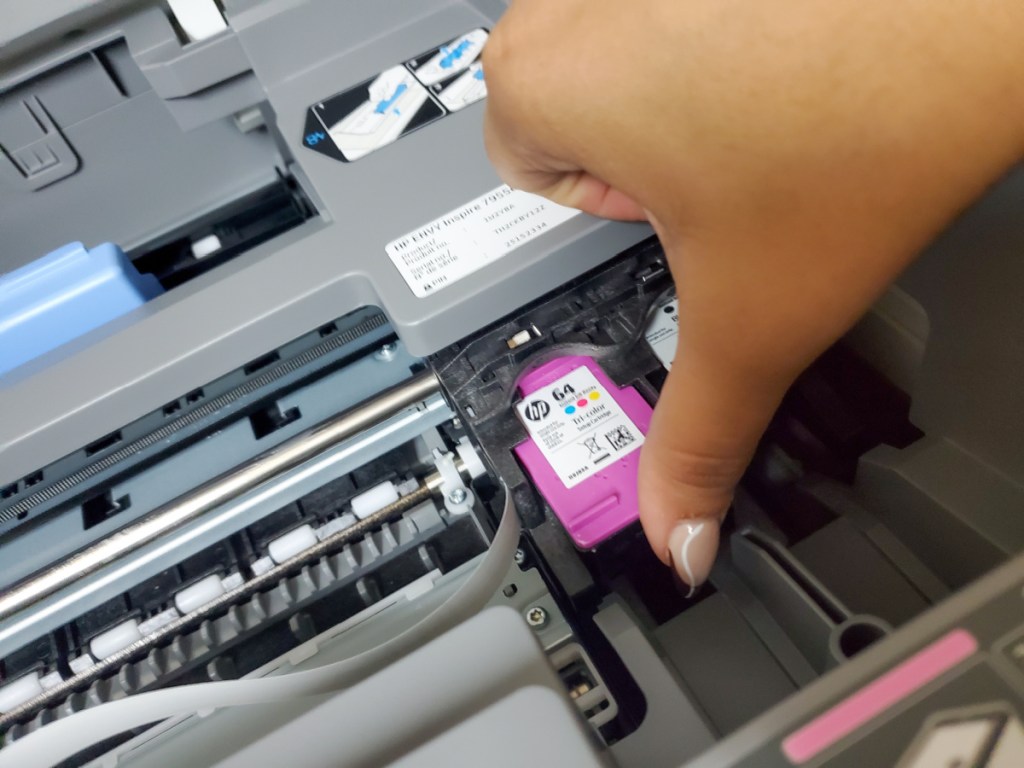 Hand inserting an Instant Ink cartridge into a printer