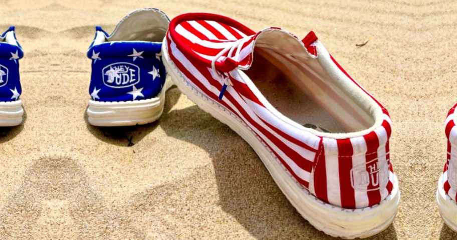 Hey Dude Patriotic Shoes with red and white stripes and stars on sand