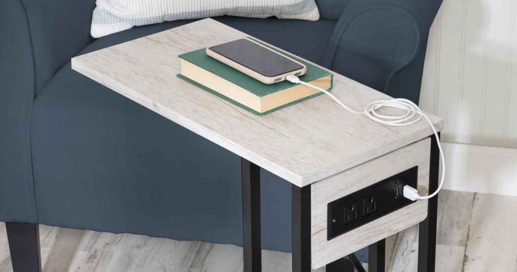 Honey Can Do Side Table with outlets witha book and a phone set on it while charging using one of the ports o the table