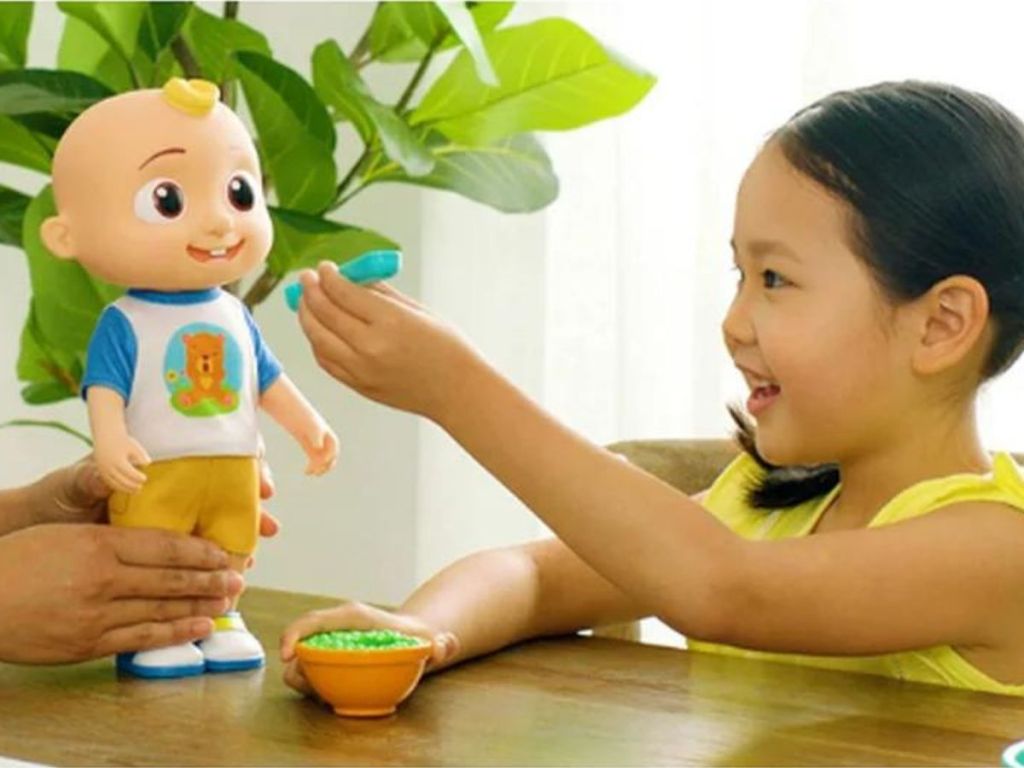 little girl feeding an interactive JJ cocomelon doll
