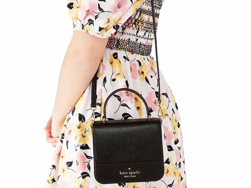 woman in a floral print dress with a black square crossbody bag