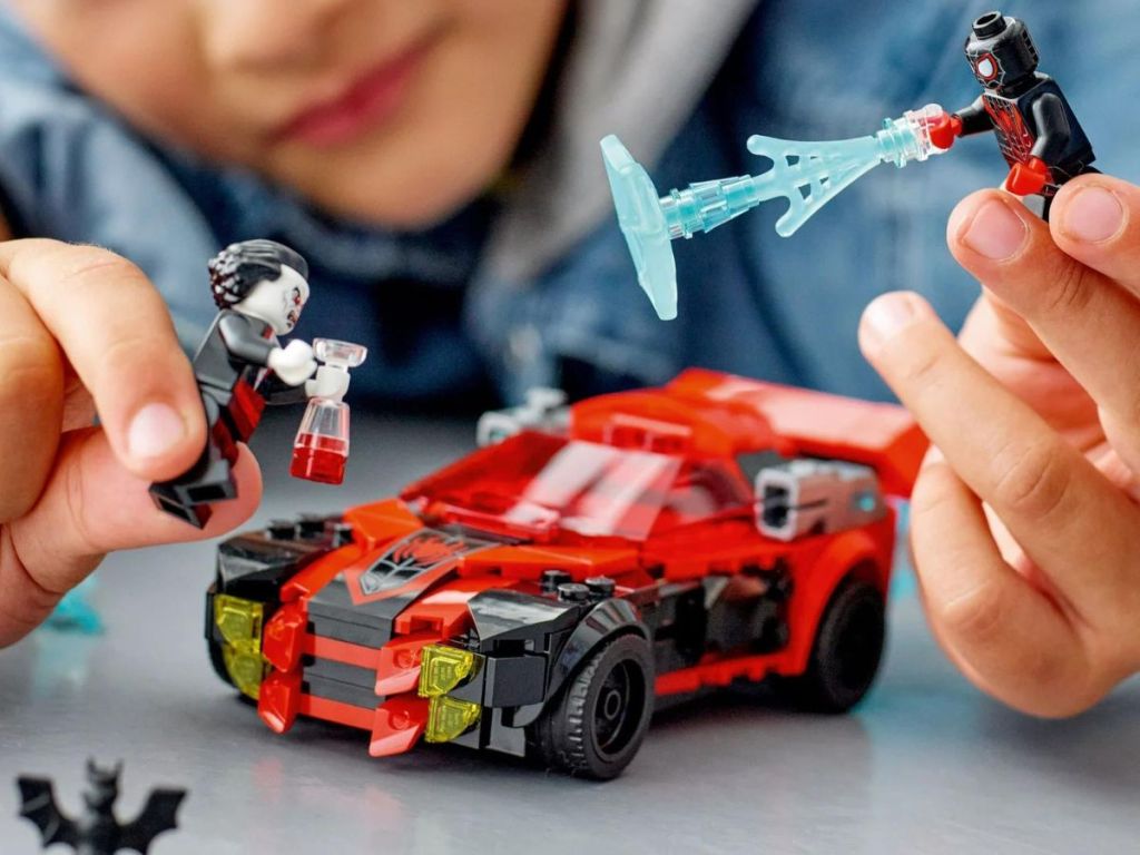 Kid playing with a Lego Spiderman Set