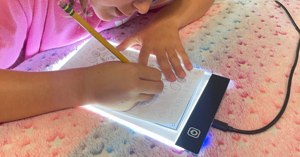 Girl using a light tracing board to trace pictures