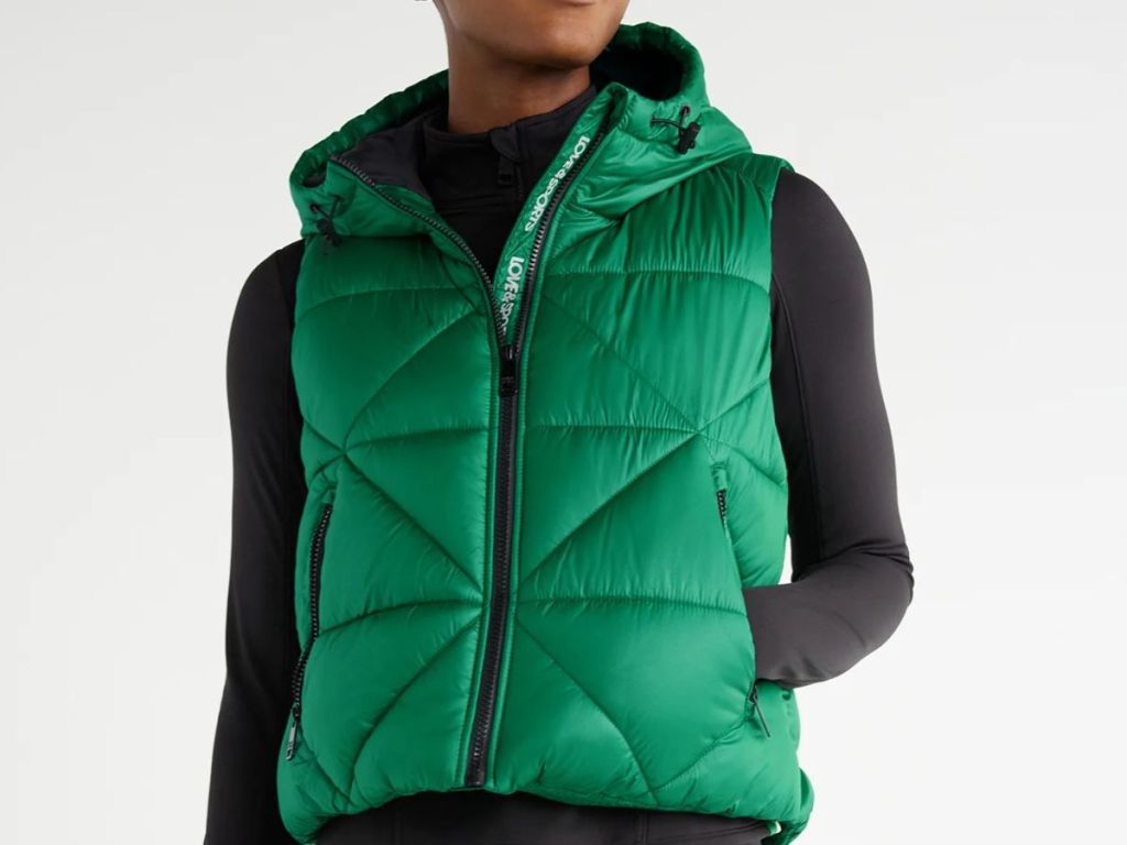woman wearing a green puffer vest with hood and a black shirt