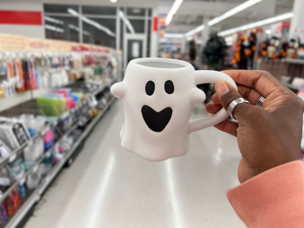 A hand holding a ghost mug