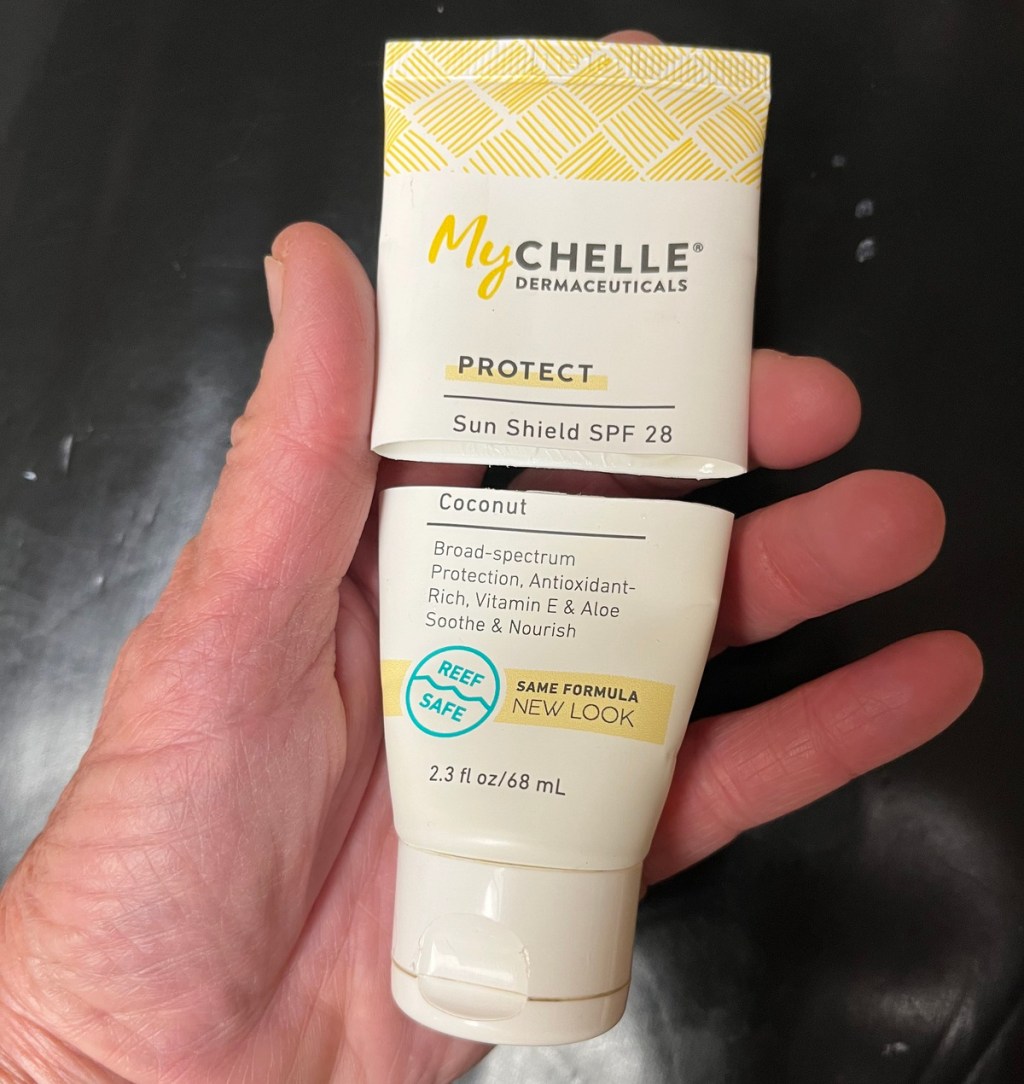 Hand holding a My Chelle Sunscreen bottle that was cut in half
