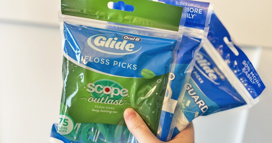 hand holding up bags of Oral-B Floss Picks