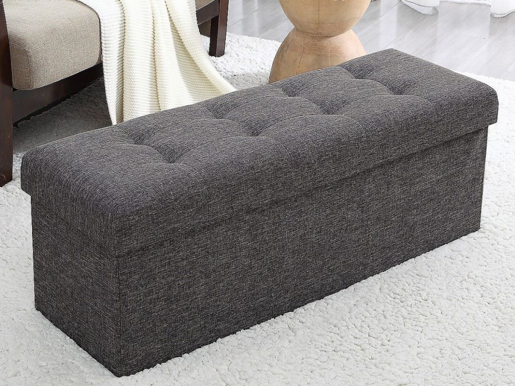 charcoal colored foldable storage ottoman with tufted top