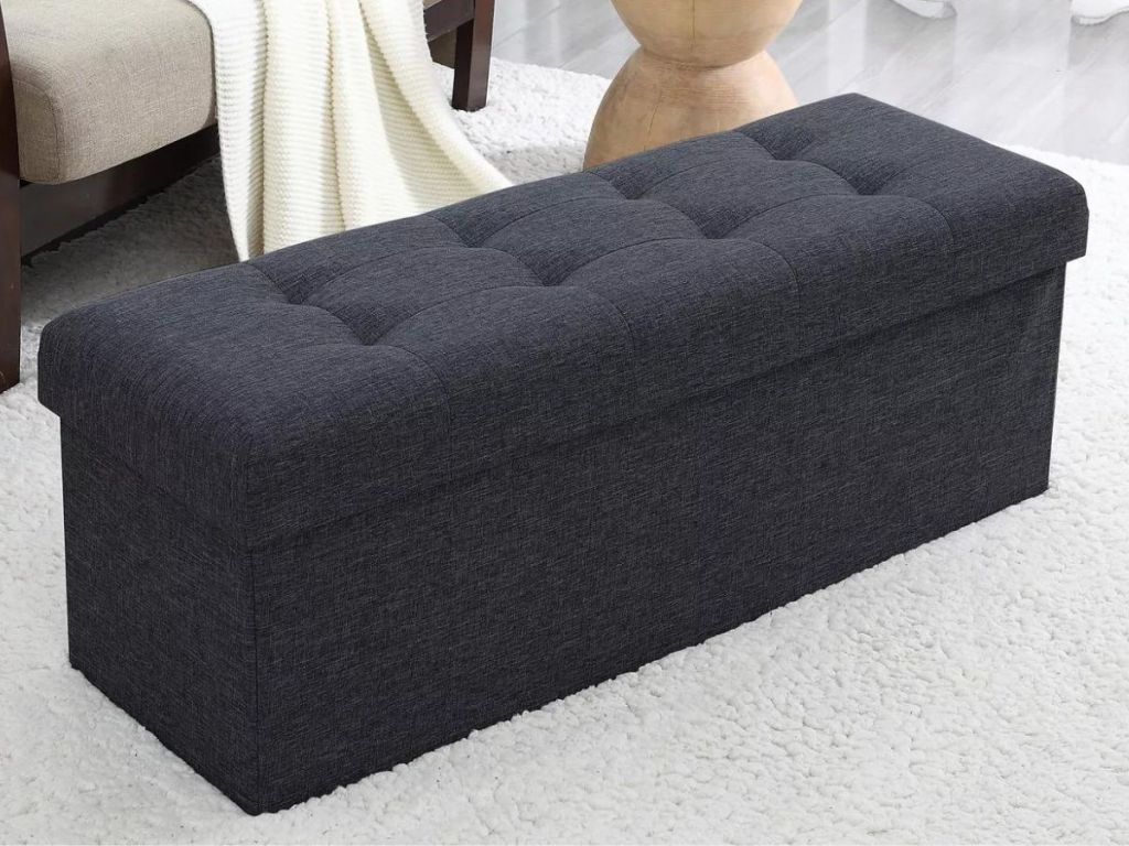 black colored foldable storage ottoman with tufted top