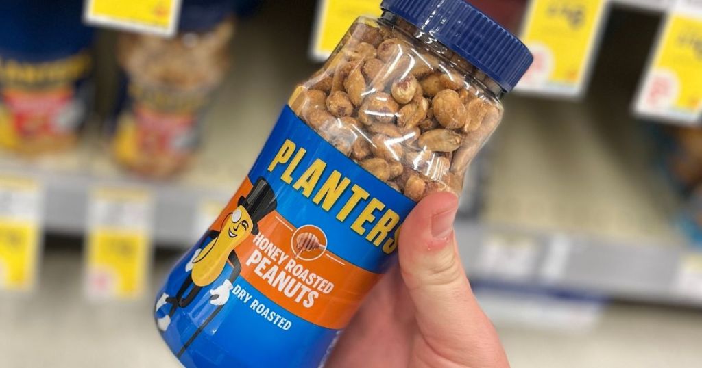 Hand holding a jar of Planters Honey Roasted Peanuts