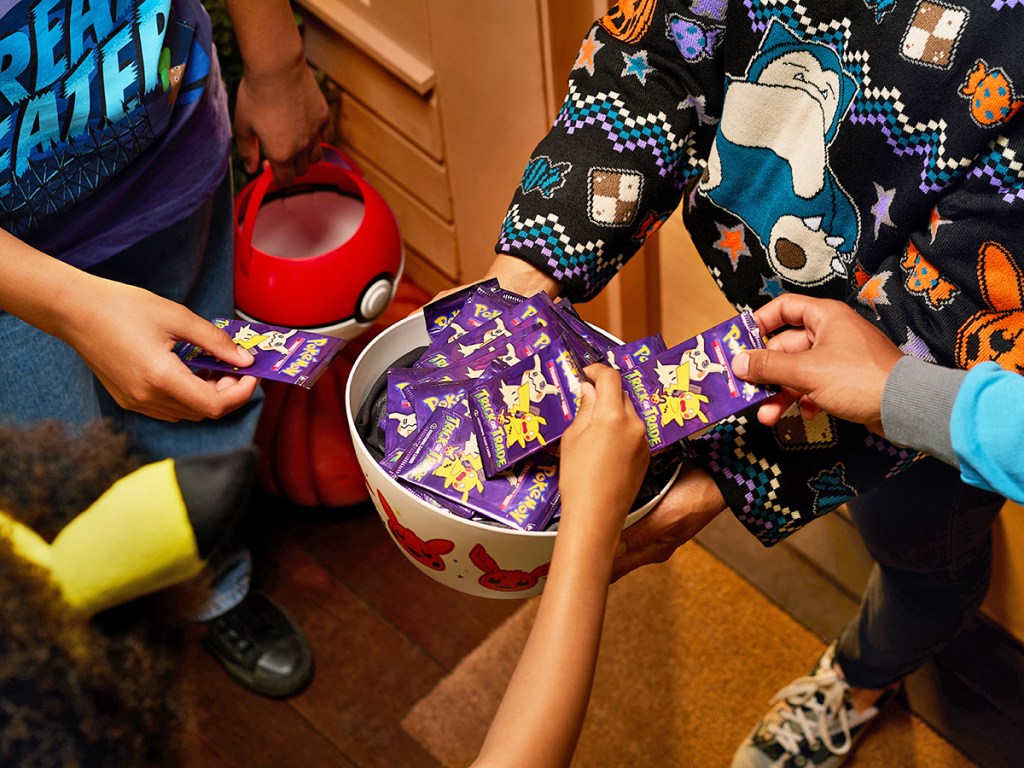 hands grabbing halloween pokemon packs from candy bowl
