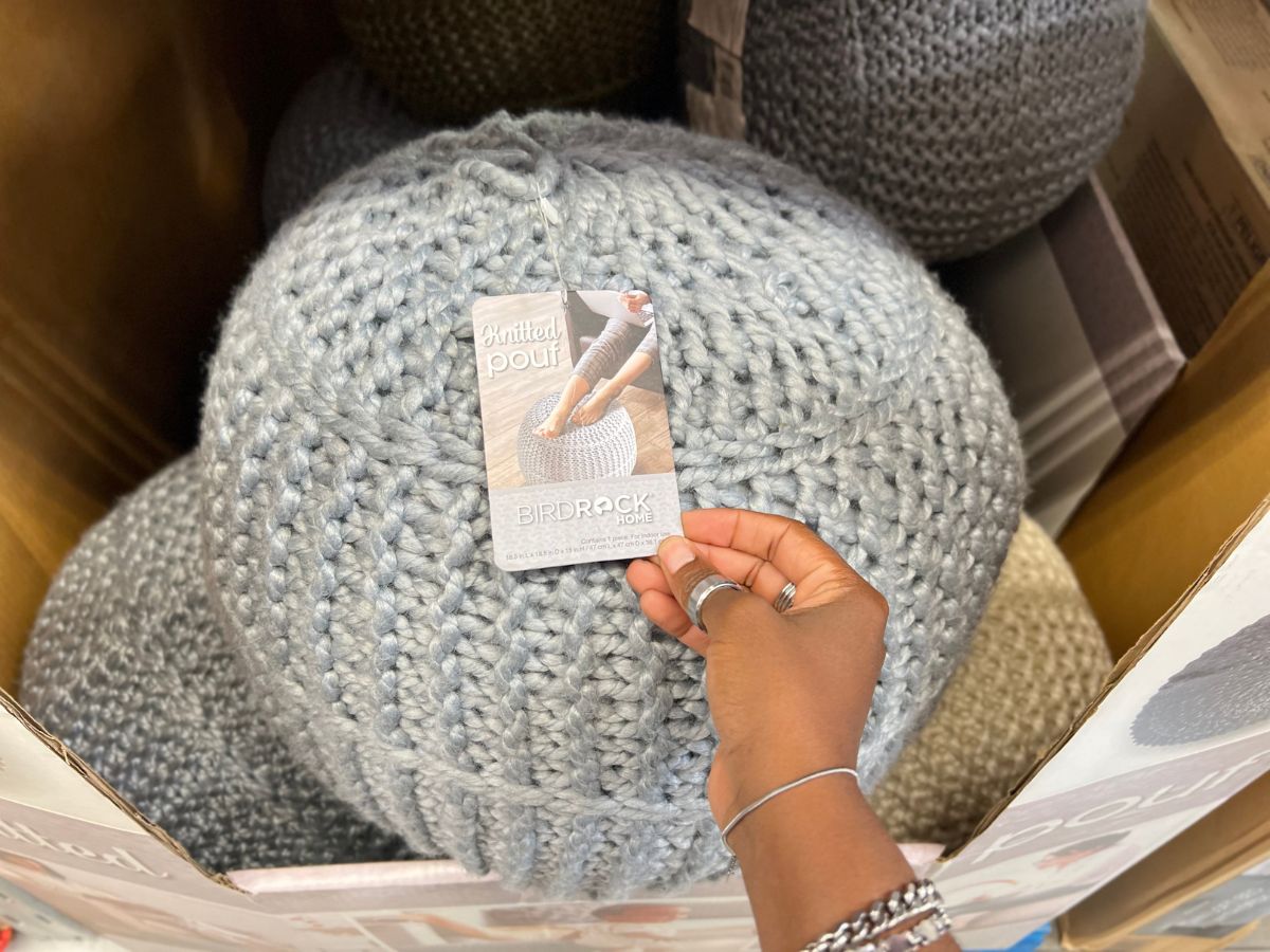 A hand showing the tag of a Sam's Club Poufs in store