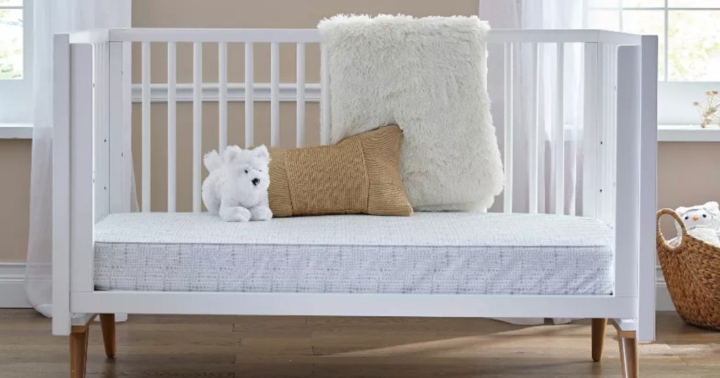 white crib with blanket and stuffed animal