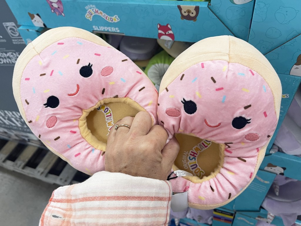 hand holding a pair of donut squishmallows slippers