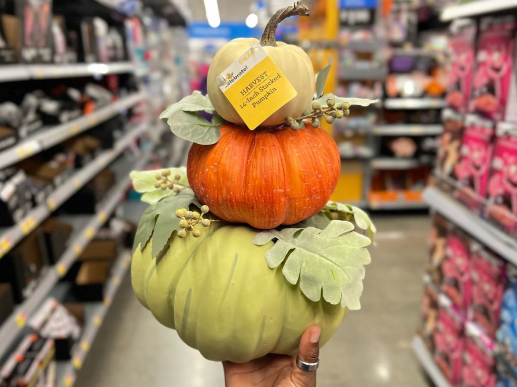 Hand holding up a stack of pumpkins decoration at Walmart