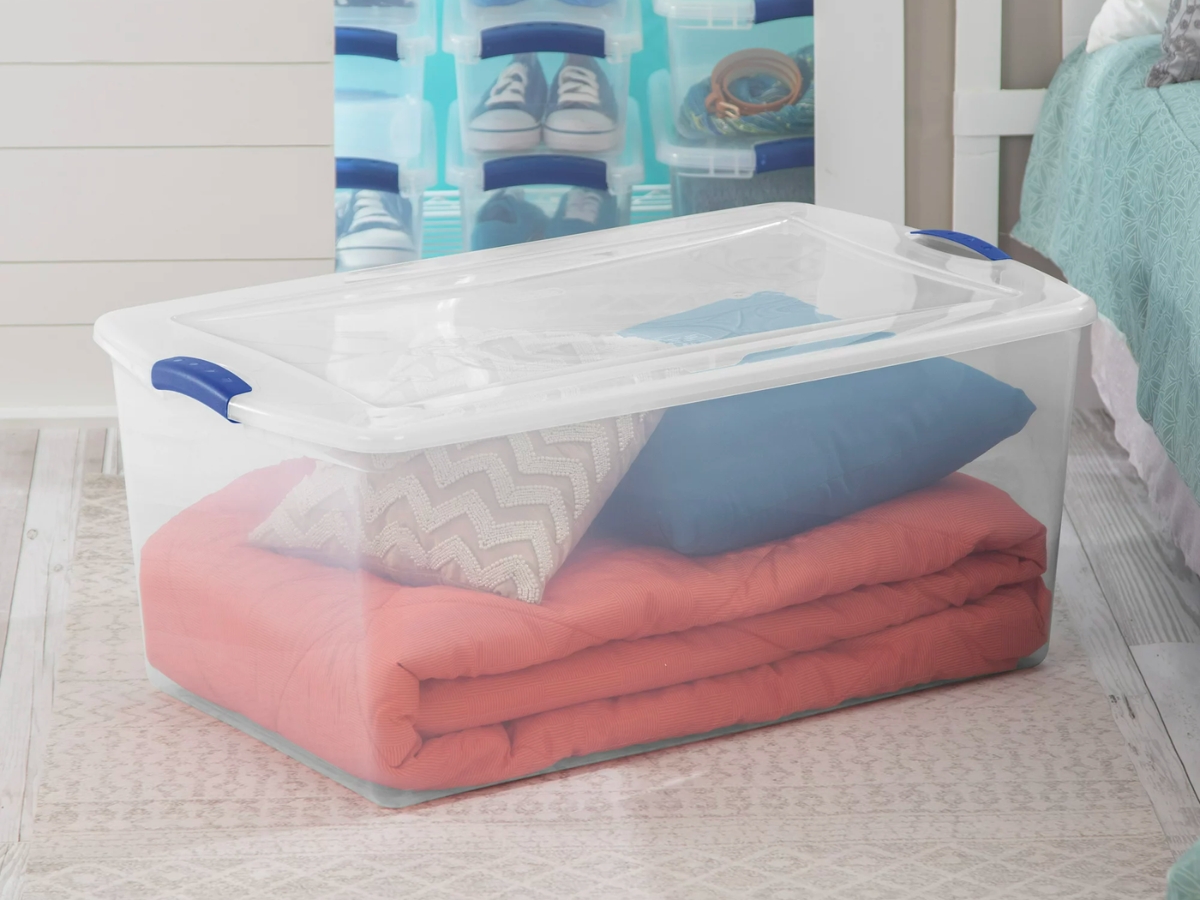 Sterilite 105qt Clear Plastic Latching Box w/ Lid with blanket and pillows inside on floor