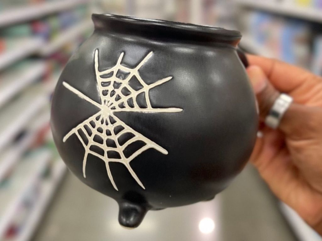 Hand holding acauldron shaped Hallowen mug at Target