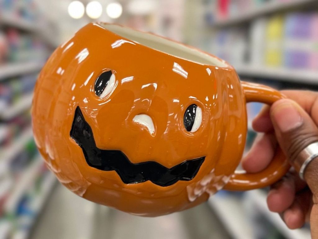 Hand holding a pumpkin shaped Hallowen mug at Target