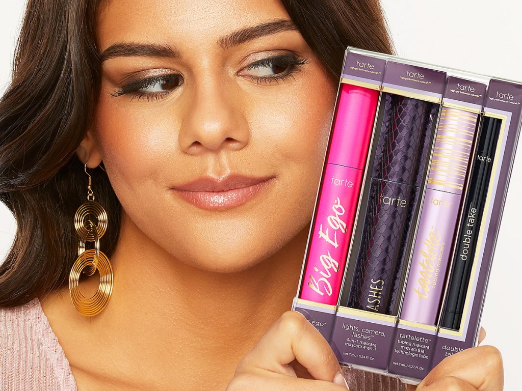 woman holding up a boxed set of tarte mascaras and eyeliner