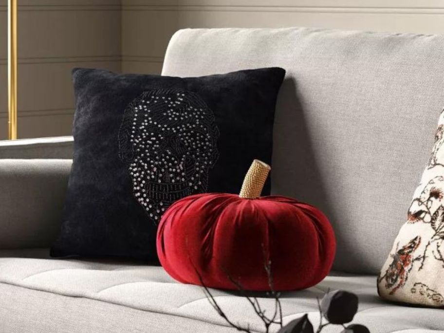 black skull and red velvet pillow on couch