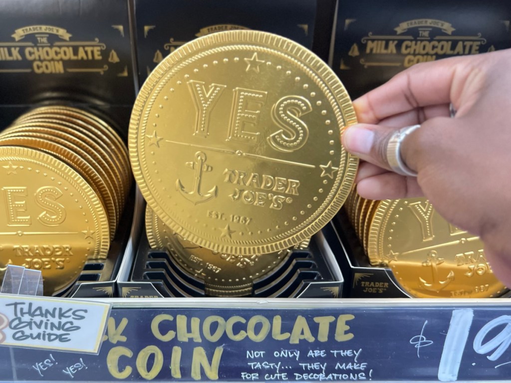 person holding large Trader Joes Dark Chocolate Coin