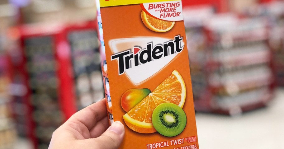 hand holding up a multi-pack of trident tropical twist gum