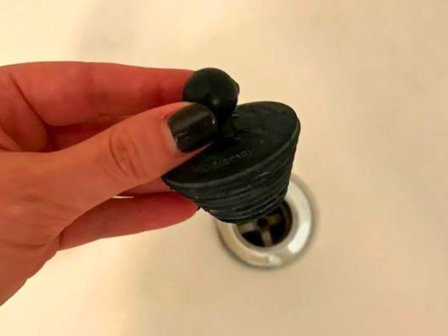 person holding tubshroom universal drain stopper 