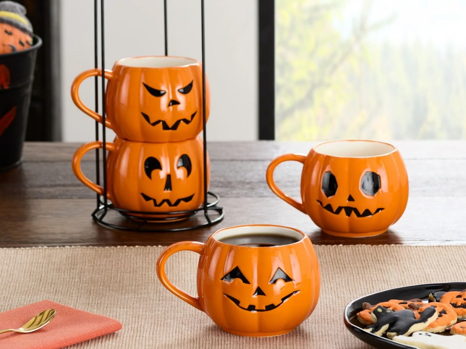 set of 4 pumpkin mugs on table