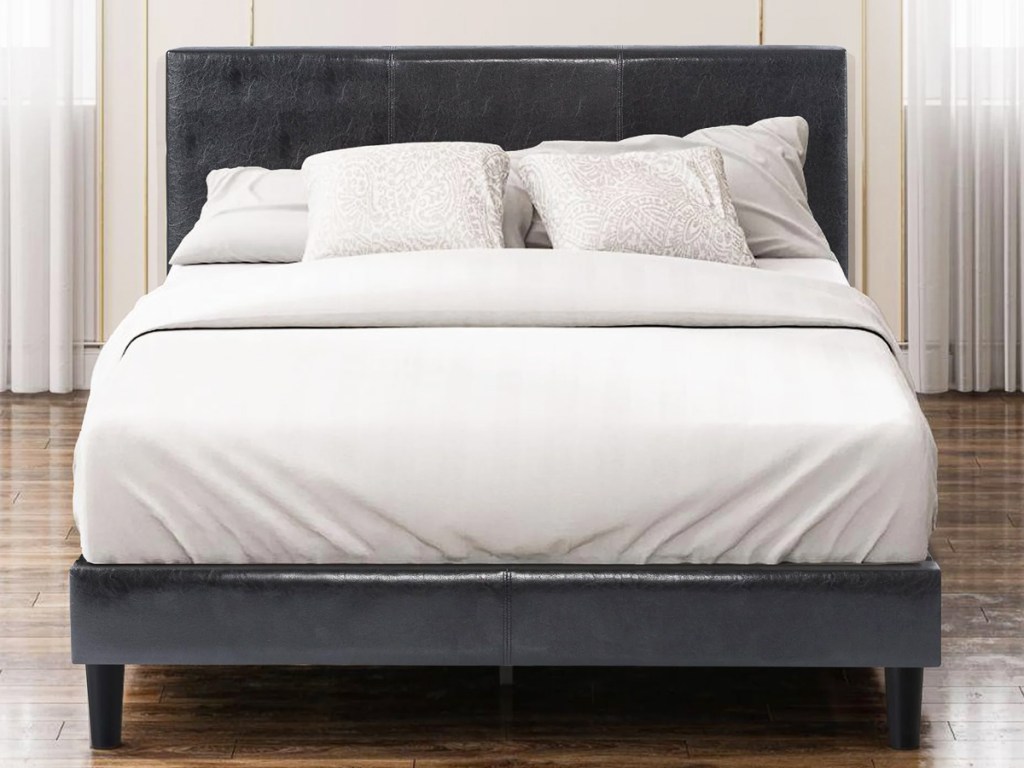 bed on a black leather bed frame with matching headboard
