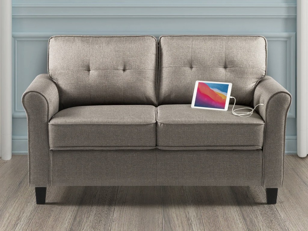 grey loveseat with ipad plugged into armrest usb port