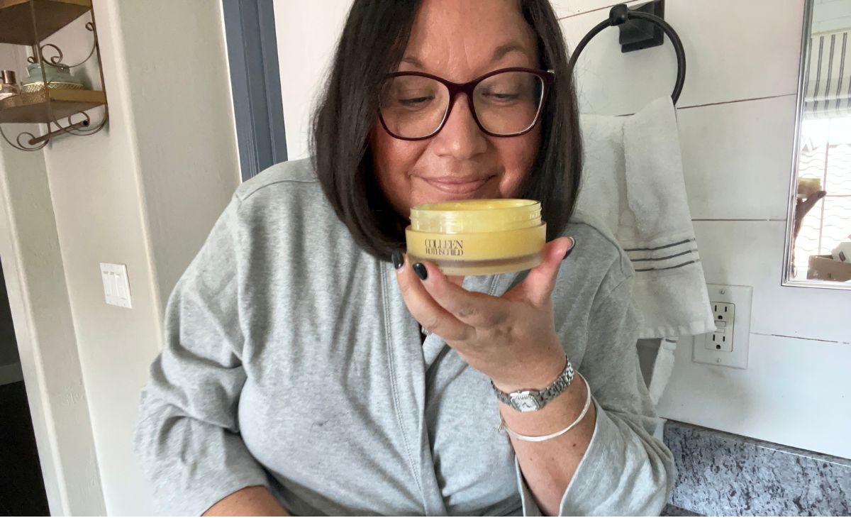 a woman sniffing a jar of facial cleansing balm