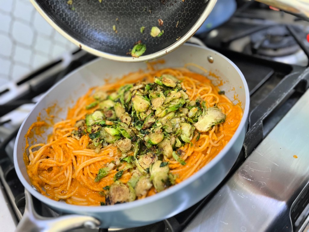 adding-cooked-brussels-sprouts-to-pasta- معكرونة قرع الجوز سهلة مع براعم بروكسل بالثوم