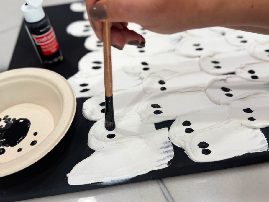 adding eyes to ghosts with craft paint 