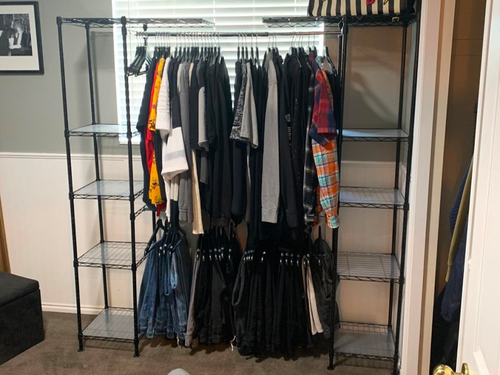 storage rack with shelves with clothes hanging. 
