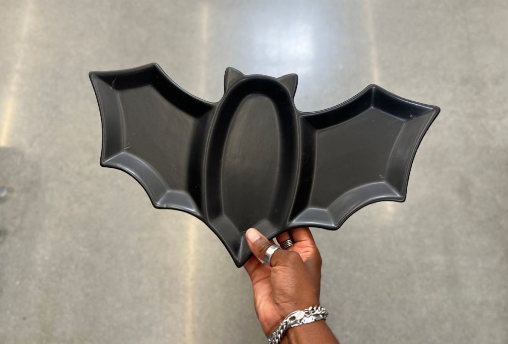a womans hand holding a bat serving tray from walmart