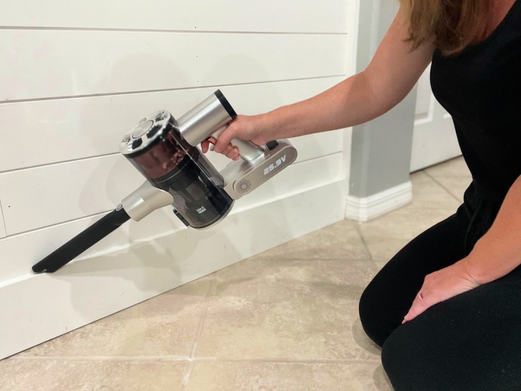 woman using a belife cordless vacuum to clean basboards