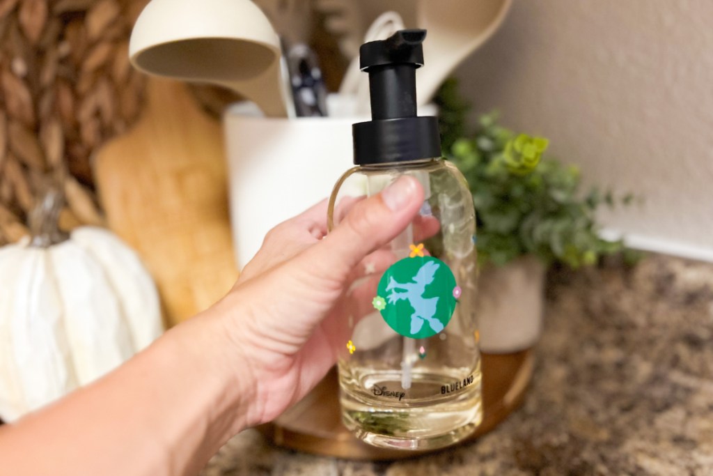 placing glass soap bottle in kitchen