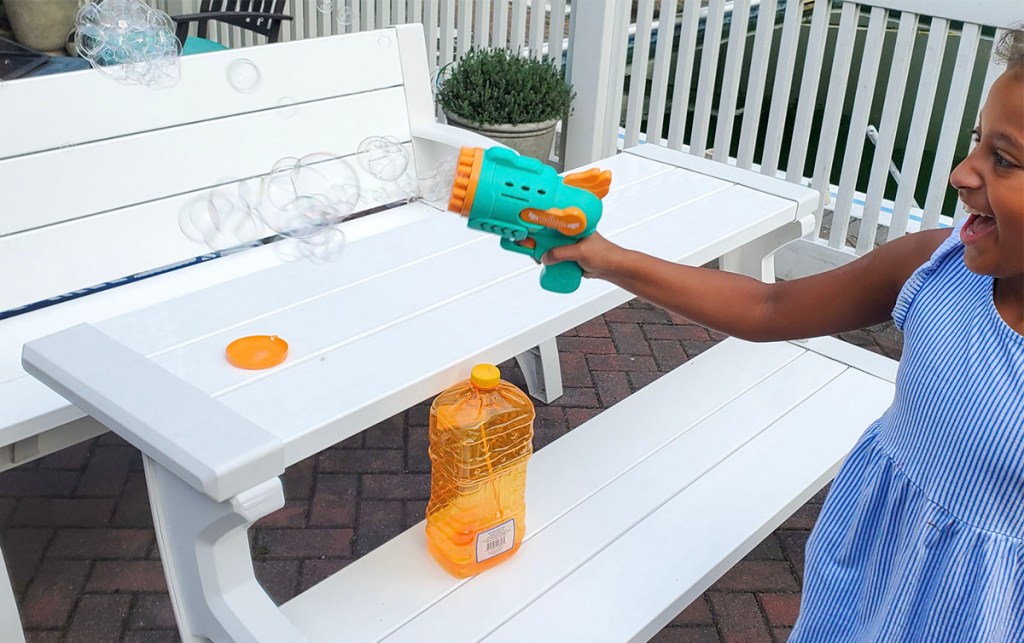 child using teal and orange bubble blower 