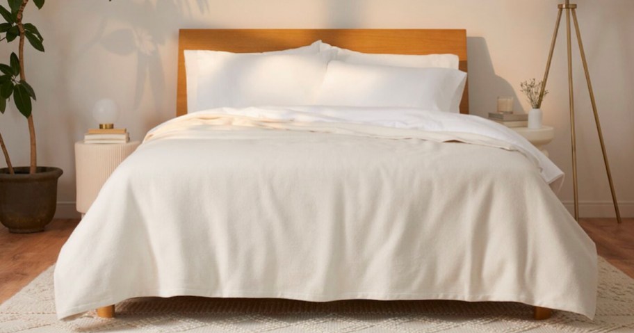 beige casper woven blanket on bed with white pillows