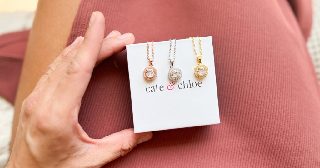 hand holding three cate and chloe necklaces