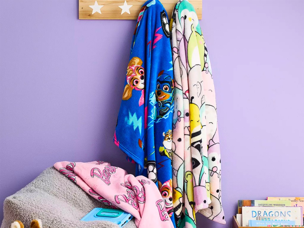 character blankets hanging on hooks on wall