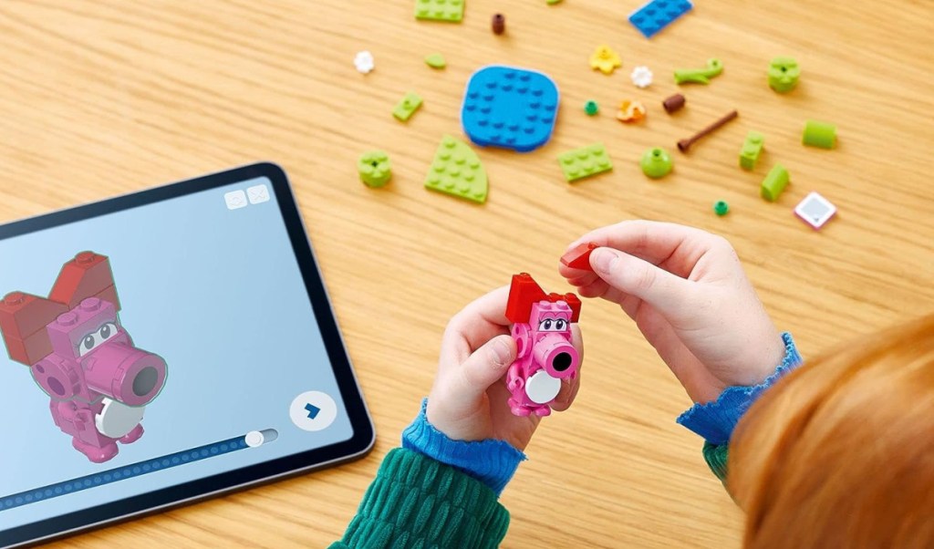 child playing with LEGO on her screen