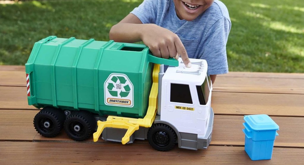 child playing with trash truck
